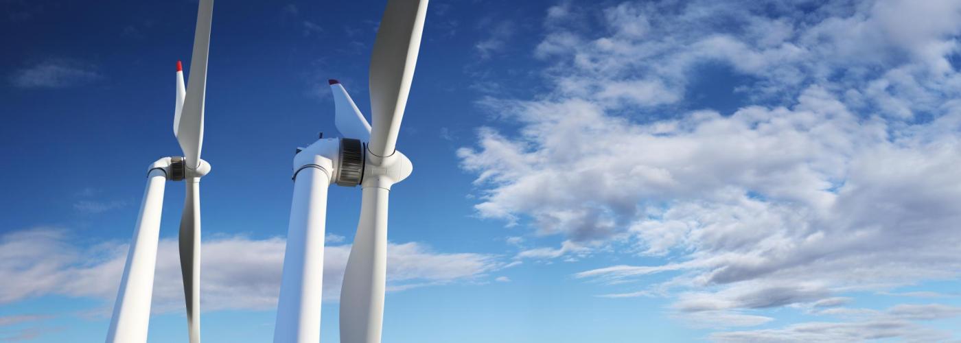 Windmills against blue cloudy sky.