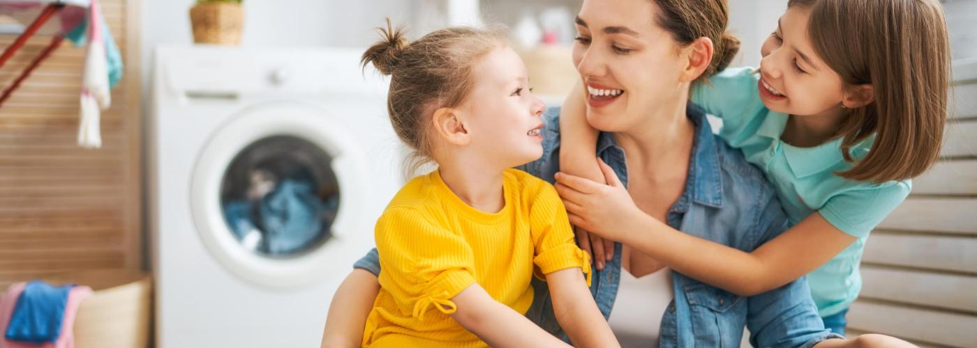 Mother and two daughters doing laundry. 