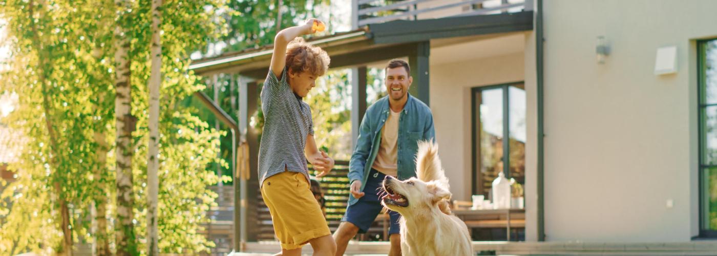 Family playing in the yard with their dog. 
