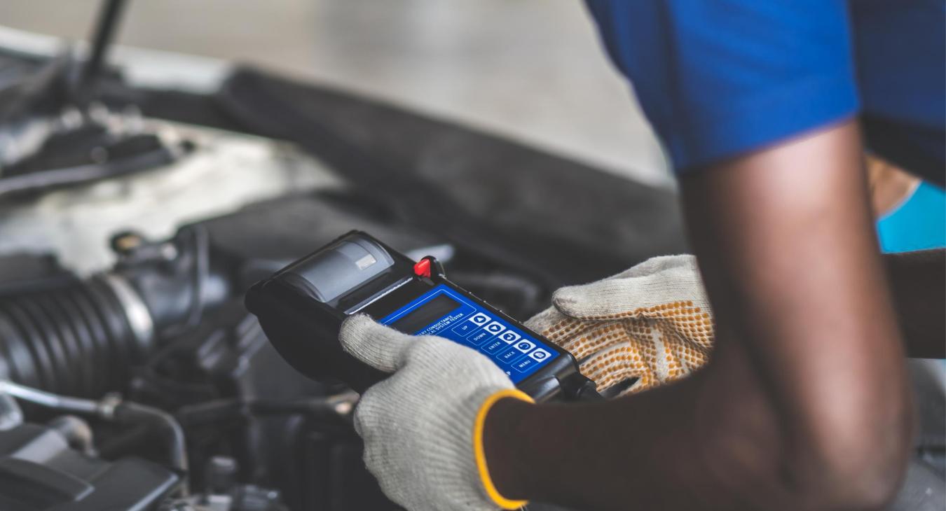 Man running diagnostics on an electric vehicle.